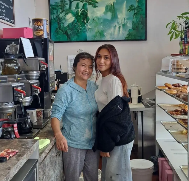 The owner of Donut House and a member of her team standing together behind the counter
